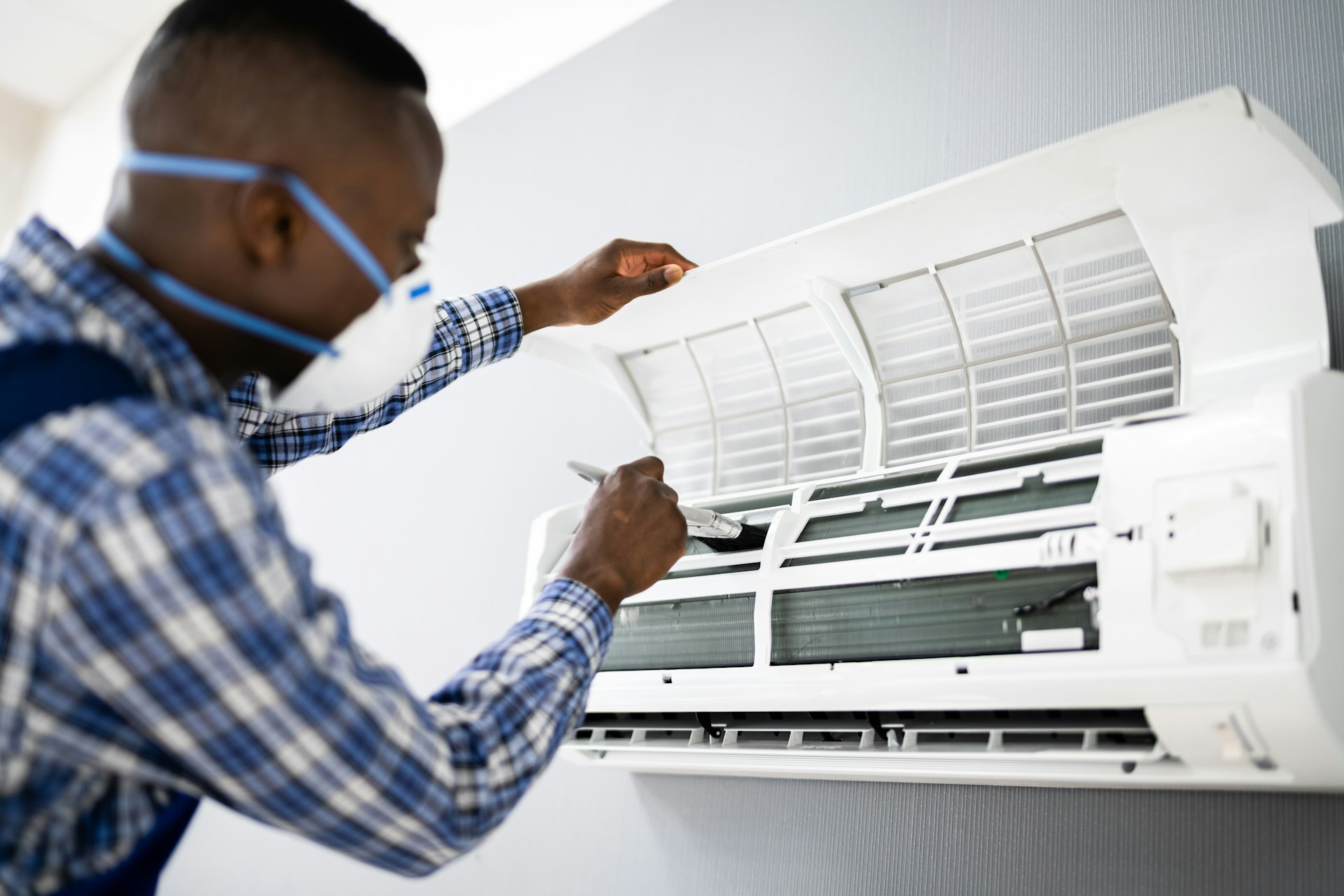 A person cleaning an AC